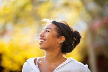 Açık havada gülen genç bir kadının yanına.