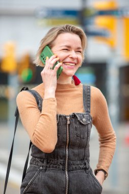 Şehirde telefonla konuşan bir kadının yakın çekimi.
