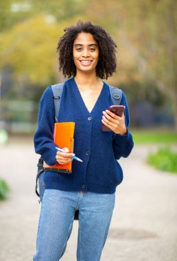 Sırt çantası ve telefonu olan genç bir kadın.