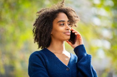 Açık havada cep telefonu kullanan Afrikalı Amerikalı Kadın