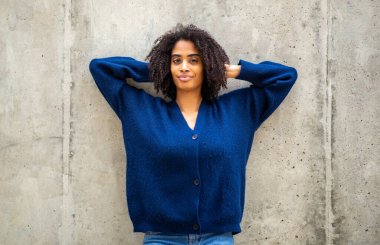 Mavi Kazaklı Güvenilir Kadın Duvara yaslanıyor