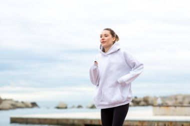 Genç bayan deniz kenarında koşuyor.