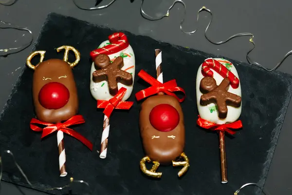 Chocolate gifts. Deer dessert and cake in Belgian chocolate on a stick. Christmas bakery. Festive food, concept of New Year and Christmas traditions. Advertisement of desserts for children. Place for