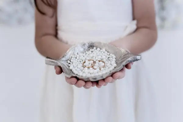 Altın alyanslar. Mücevher aksesuarları. Ürün konsepti. Hayat. Yüzük. 5 yaşındaki kız bir çift için alyans tutuyor..