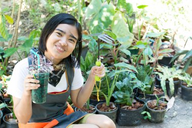 Bahçede çiçek düzenleyen kız.