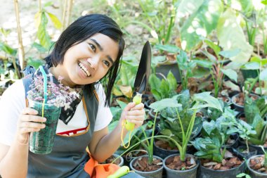 Bahçede çiçek düzenleyen kız.