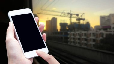 Kadın eli şehrin arka planında ulaşım için akıllı telefon kullanıyor.