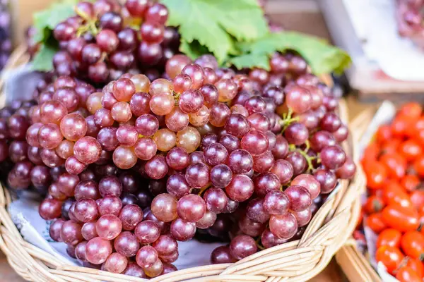 Markette taze taze kırmızı böğürtlen ve yeşil üzüm sepeti