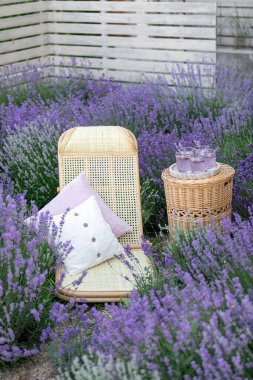 Lavanta tarlasında bir bardak limonata. Arka planda mor çiçekler