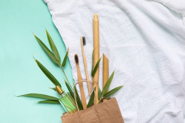 Bambu diş fırçası ve eco çantası mavi arka planda fotokopi alanı olan bir masada. Düz yaprak ve bambu yapraklarının şekillendirilmiş bileşimi