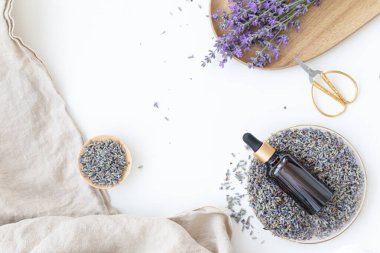 Bir şişe kehribar lavanta yağı. Düz konsept deri bakımı. Lavend çiçekli hafif arkaplan