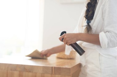 Genç bir kadın mutfağı ekolojik ürünlerle temizliyor.