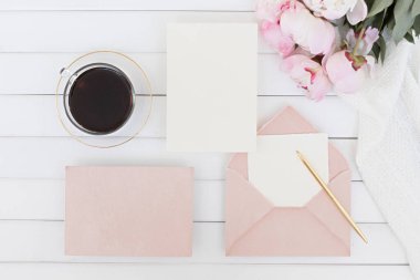 Düğün kartı konsepti. Ahşap arka planda şakayık çiçekleri olan üst görünüm. Açık renklerde düz uzanma biçimi