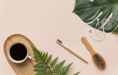 Fotokopi alanı olan düz konsept. Pembe arka planda sabah aksesuarları ve kurumuş tropikal yaprak