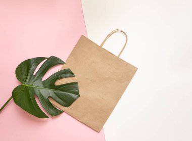 Poşetli ve tropikal yapraklı düz konsept. Zarif aksesuarları olan zarif bir kompozisyon