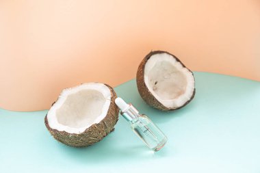 Hindistan cevizi yağı ve çiçek masanın üstünde pastel arka planda fotokopi alanı var. Düz zeminin tropikal arkaplan ile biçimlendirilmiş bileşimi