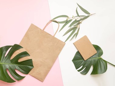 Poşetli ve tropikal yapraklı düz konsept. Zarif aksesuarları olan zarif bir kompozisyon