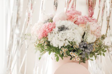 Pembe bir kutuda zarif bir buket gül, şakayık ve papatya. Işıkla dolu bir pencere tarafından güzelce düzenlenmiş ve yerleştirilmiş. Yüksek kalite fotoğraf. Doğum günleri ve düğünler için harika bir hediye.