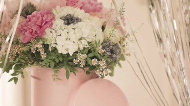 Pembe bir kutuda zarif bir buket gül, şakayık ve papatya. Işıkla dolu bir pencere tarafından güzelce düzenlenmiş ve yerleştirilmiş. Yüksek kalite fotoğraf. Doğum günleri ve düğünler için harika bir hediye.