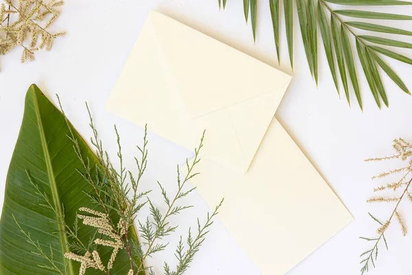 Styled summer wedding desktop stationery mockup. Blank greeting and invitation card. Green tropical leaves with empty space