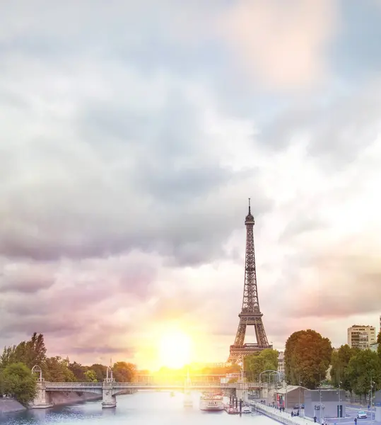 बादलों के साथ एफ़ेल टॉवर सूर्यास्त। रोमांटिक सूर्यास्त पृष्ठभूमि। पेरिस, फ्रांस में सीन नदी पर नावों के साथ पुराना स्मारक . — स्टॉक फ़ोटो, इमेज