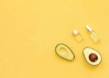 Tropikal arka planda gerekli yağlar ve avokado. Deri ve vücut bakımı kavramı
