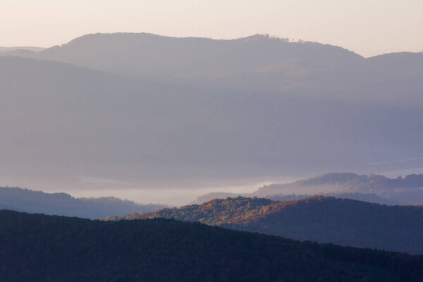 гористый туманный пейзаж на рассвете. Туманные пейзажи осенней сельской местности. красивый вид вдалеке, полный утреннего тумана