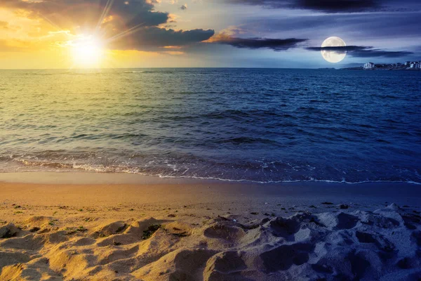 summer vacation background at the sea with sun and moon. day and night time change concept. clear water and sandy beach at twilight. relax and recreation season