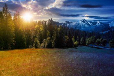 carpathian mountain landscape at summer twilight. day and night time change concept. beautiful countryside with forested hills and road through the valley with sun and moon