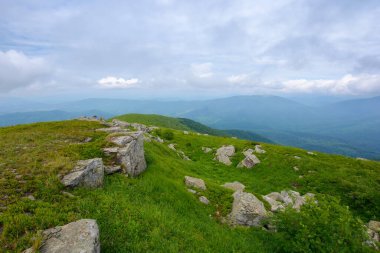 Yağmurlu bir günde Karpatlar 'ın dağ manzarası. Çimenli tepeler ve çayırlardaki taşlar ve kayalar. öngörülemeyen hava tahmini kavramı