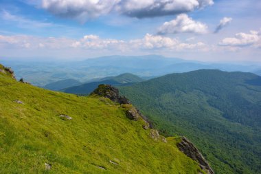 summer mountain landscape. rocks on the grassy hills. beautiful scenery on a sunny day