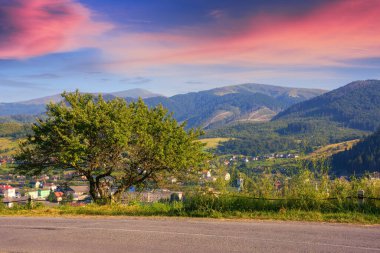 as the sun sets, the road leads through a beautiful countryside. journey continues promising a beautiful scene at every turn