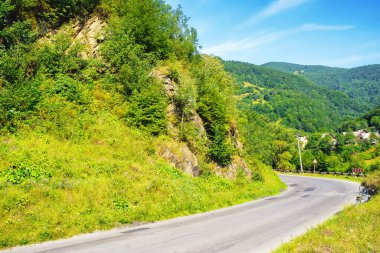 Yol, gezginlere manzaralı bir yol sunarak huzurlu kırsal kesimden geçiyor. Huzurlu manzara sadece ufuktaki görkemli dağlar tarafından bölünür.