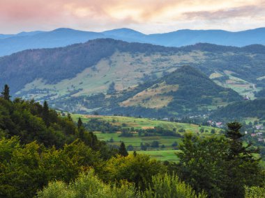 kırsal vadi ve dağların üzerinde gün doğumu. Tepelerdeki çimenli tarlalar ve çayırlar