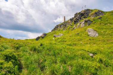 Pikui dağının dik yamaçlarında kayalık oluşumlar. Güneşli bir yaz gününde Ukraynalı Karpatların doğa manzarası. Kabarık bulutlu mavi gökyüzü