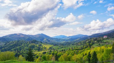Kırsal dağ vadisinde gün batımı. Yuvarlanan tepeler ve dağ zirveleri çarpıcı bir zemin sağlar.