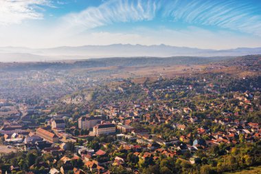 Puslu bir sabahta küçük bir kasaba devasının manzarası. Romanya 'nın Karpat Dağları' ndaki güzel şehir manzarası