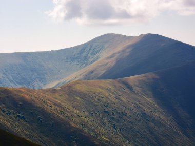 Sonbahar renklerinde Karpatlar. Akşam ışığında renkli dağlık tepeler ve çayırlar olan doğa arka planı