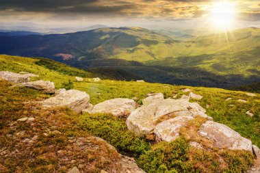 Gün batımında dağın tepesine yakın yamaçta beyaz, keskin kayalarla kaplı bir manzara. Güzel kırsal manzara Akşam ışığında