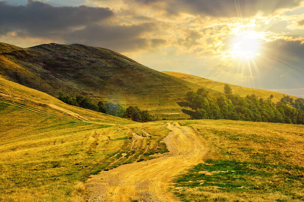 early autumn mountain landscape with path through the hillside at sunset. beautiful countryside scenery in evening light