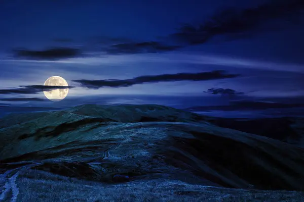 mountain landscape at night. path through hills to the mountain top. wonderful nature scenery in full moon light