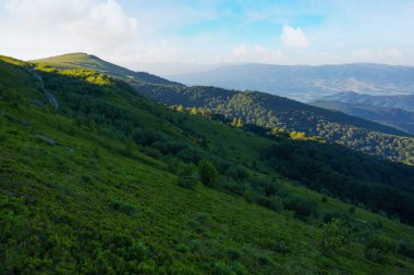 Dağlık doğa geçmişi. Sabah ışığında yaz manzarası. Çimenli yamaçları olan runa dağının yuvarlanan manzarası