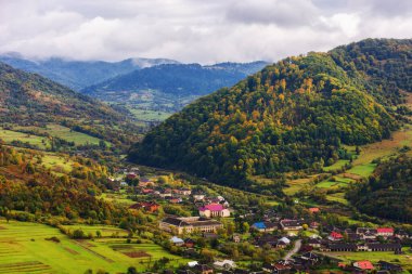 Karpatya dağlarının kırsal manzarası. Sonbahar mevsiminde güzel kır manzarası tepelerde tarlalar ve vadide köyler