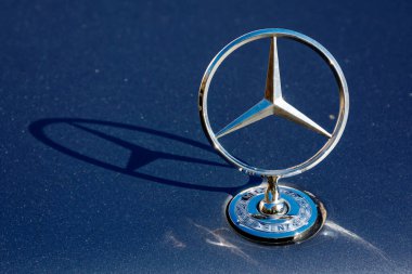 Uzhgorod, Ukrayna - 31 Ekim 2021: Mercedes Benz yıldız maskotu bir w123 'ün koyu mavi kaputunda parlıyor. Metalik yüzeye süs damlası