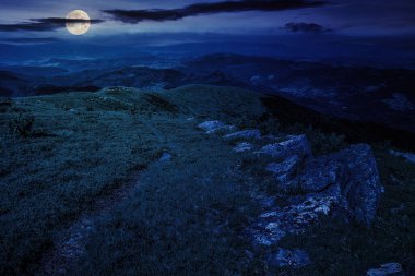 Gece vakti, yüksek barbar dağlarındaki yamaçtaki çayırlarda keskin kayalar. Dolunay ışığında harika bir doğa manzarası