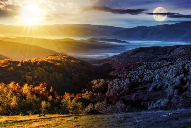 Dağlarda soğuk sis. Alacakaranlıkta güneş ve ay olan bir gökyüzünün altındaki kırsal vadi. Gündüz ve gece zaman kavramını değiştirir. Gizemli kırsal manzara Sabah ışığında