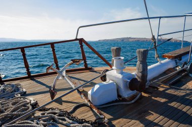 Açık denizdeki bir geminin burnundan manzara. Ufukta bir ada görünüyor. güneşli hava