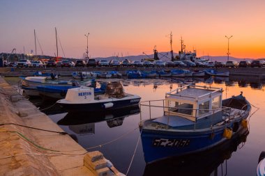 Sozopol, Bulgaria - 03 sep 2019: alacakaranlıkta limanda küçük balıkçı tekneleri. Bulutsuz gökyüzü suya yansıyor