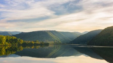 Gün batımında gölü olan dağlık bir manzara. Akşam ışığında çok güzel bir arka plan. Romanya, Cluj İlçesi