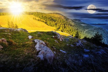 Sonbaharda kozalaklı ormanı olan dağ manzarası ve alacakaranlıkta güneşi ve ayı olan çayır. Gündüz ve gece zaman kavramını değiştirir. Gizemli doğa manzarası Sabah ışığında